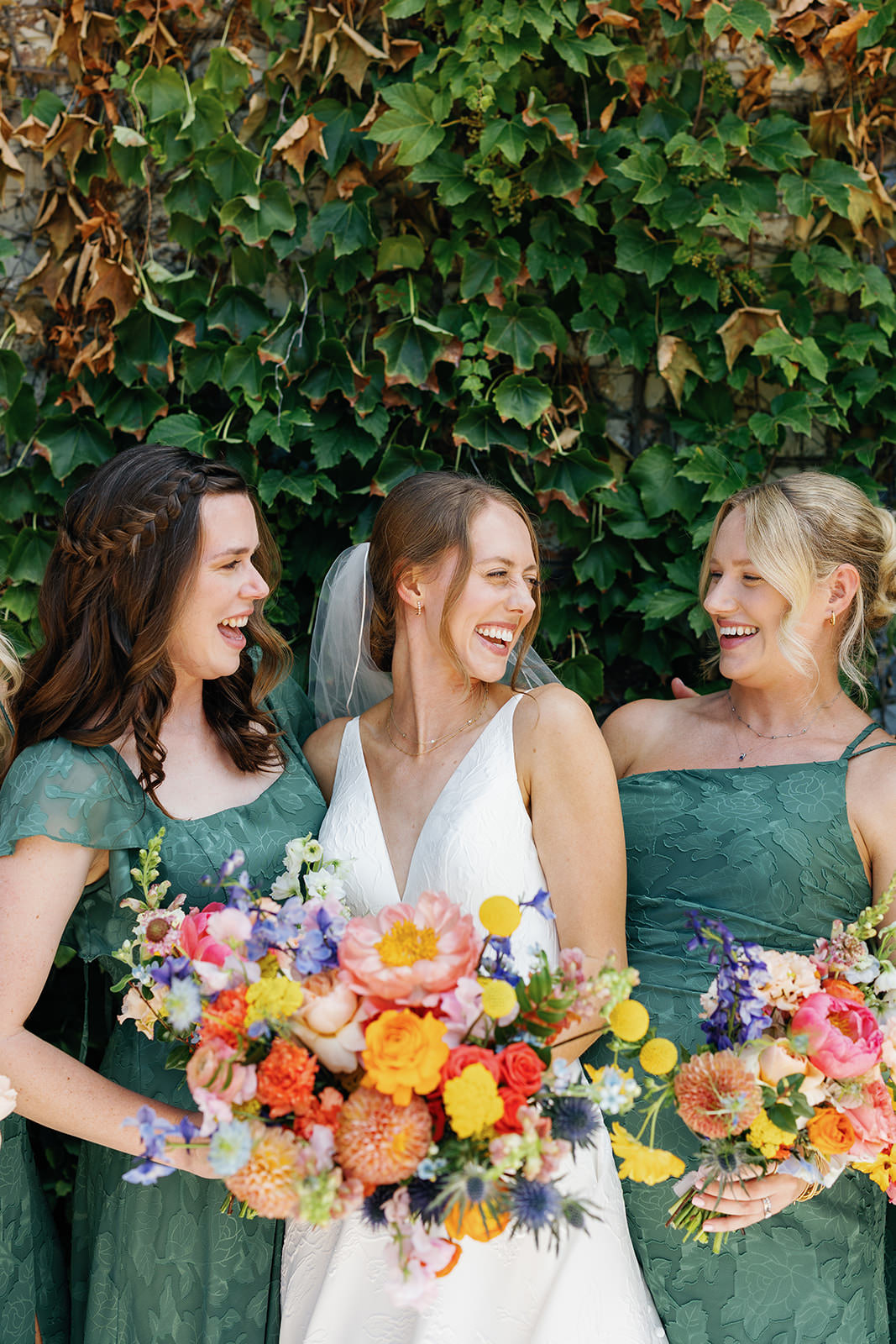 Bride with bridesmaids in green dresses holding bright bouquets