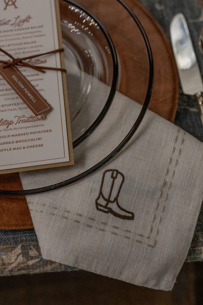 Rustic tablescape at Lonesome Dove with layered linens and amber glassware.