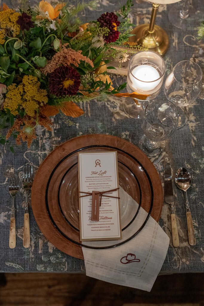 Candlelit dinner setup at Lonesome Dove featuring rich fall tones and florals.