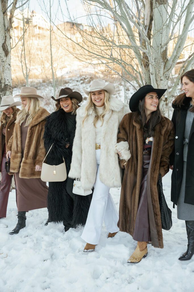 Guests wearing fur coats and cowboy hats at an apres ski welcome party
