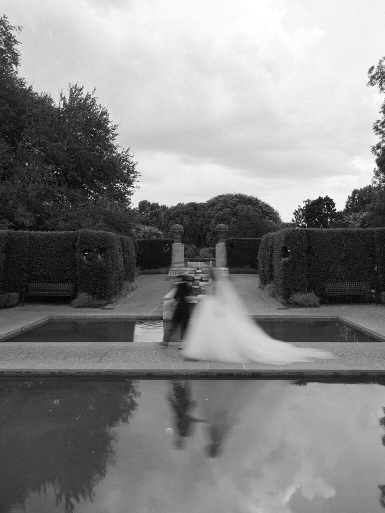 Bride and groom kissing in garden walkway at Dallas Arboretum