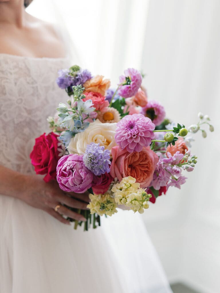 Bride holding vibrant garden bouquet before Dallas Arboretum ceremony