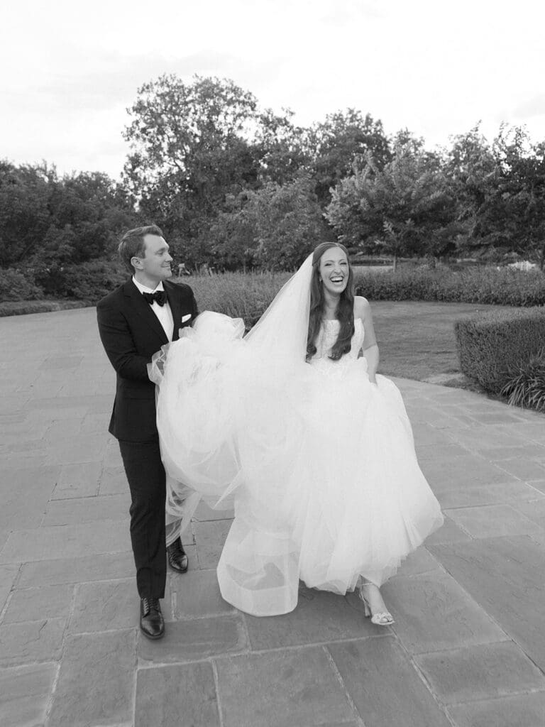 Bride and groom walking through Dallas Arboretum gardens